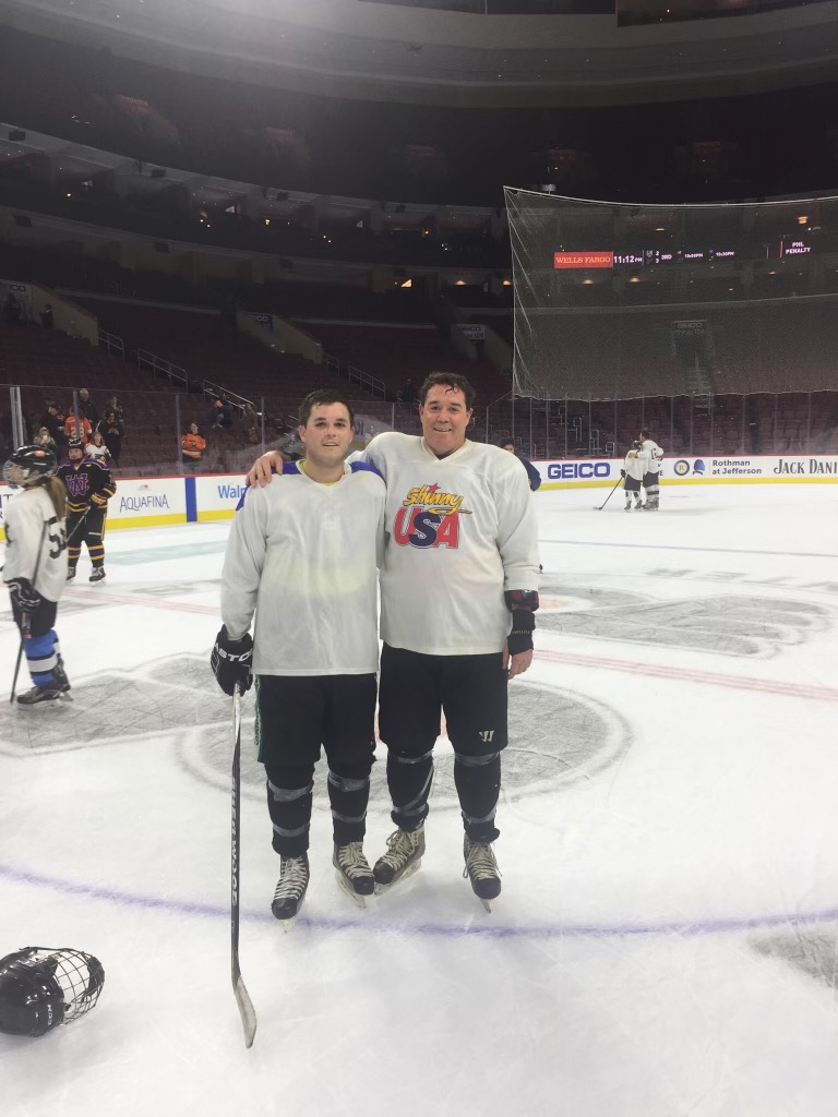 Martin Belisario on an ice rink with a young man in hockey gear